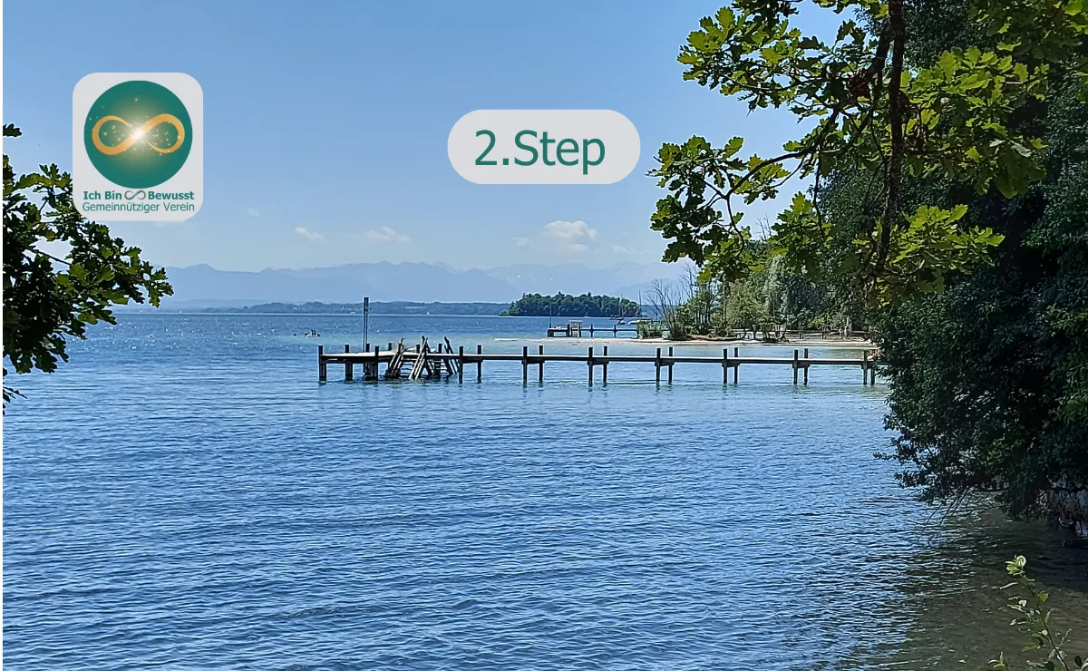 Ein ruhiger See mit Holzsteg und klarem Wasser, von grünen Bäumen gerahmt, im Hintergrund Berge. Bildaufschrift: 2. Step.