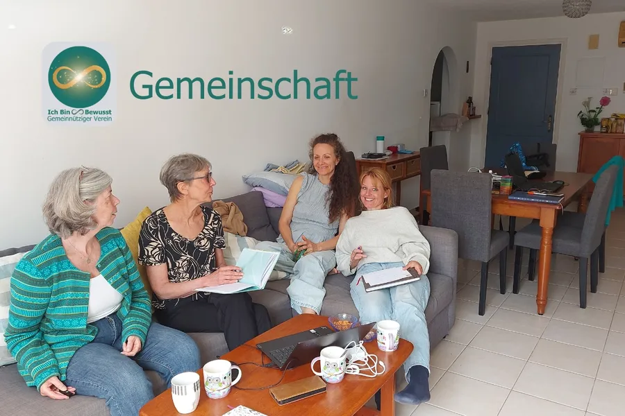 Vier Frauen sitzen mit Notizbüchern und Tassen zusammen und unterhalten sich.